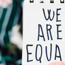 Image of a women with a we are equal note for Maternity Discrimination header image