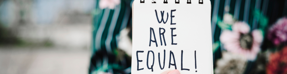 Image of a women with a we are equal note for Maternity Discrimination header image