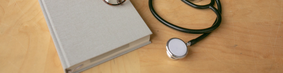 Image of a Stethoscope and Book for World Cancer Day Employment Article