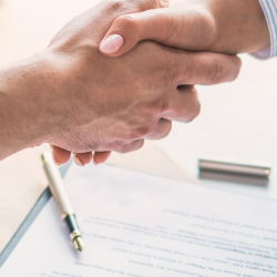 Image of staff shaking hands over an updated employment contract
