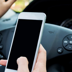 image of an employee using a phone whilst driving.