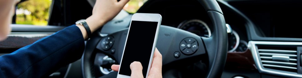 image of an employee using a phone whilst driving.