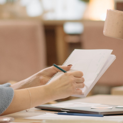 Image of two staff talking while one takes notes.