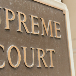 Image of supreme court sign with a solicitor standing in the background as page header image