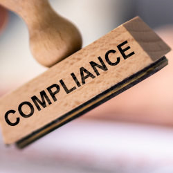 Image of a compliance stamp and documents for article header image