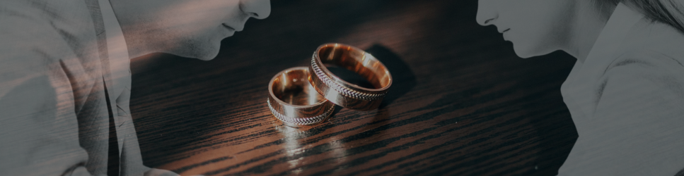 Siluettes of a man and women with wedding rings on the table between them,