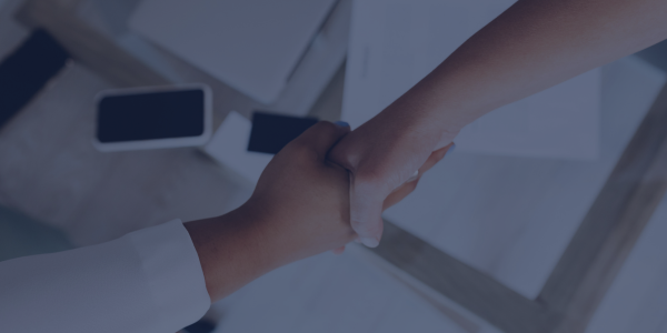 Image of hands shaking over work documents for settlement agreements header image.